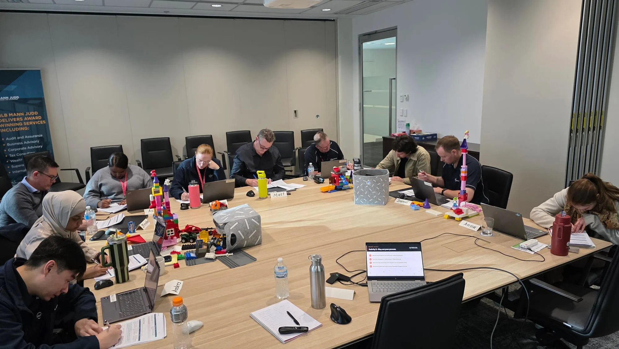 The HLB Mann Judd Wealth Management team working through a hands-on activity around the boardroom table